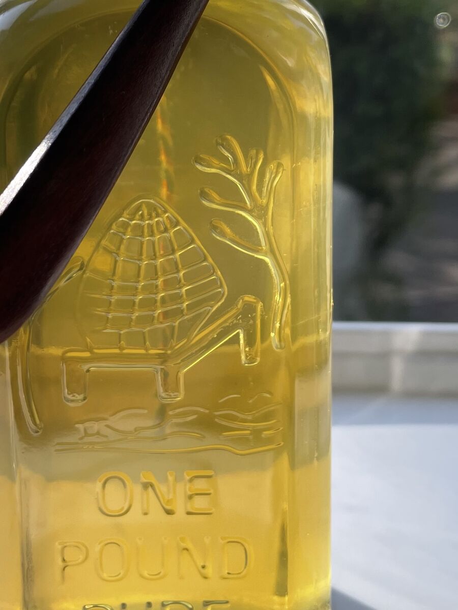 Close-up of the embossed straw skep and the words One Pound Pure on the gift bottle